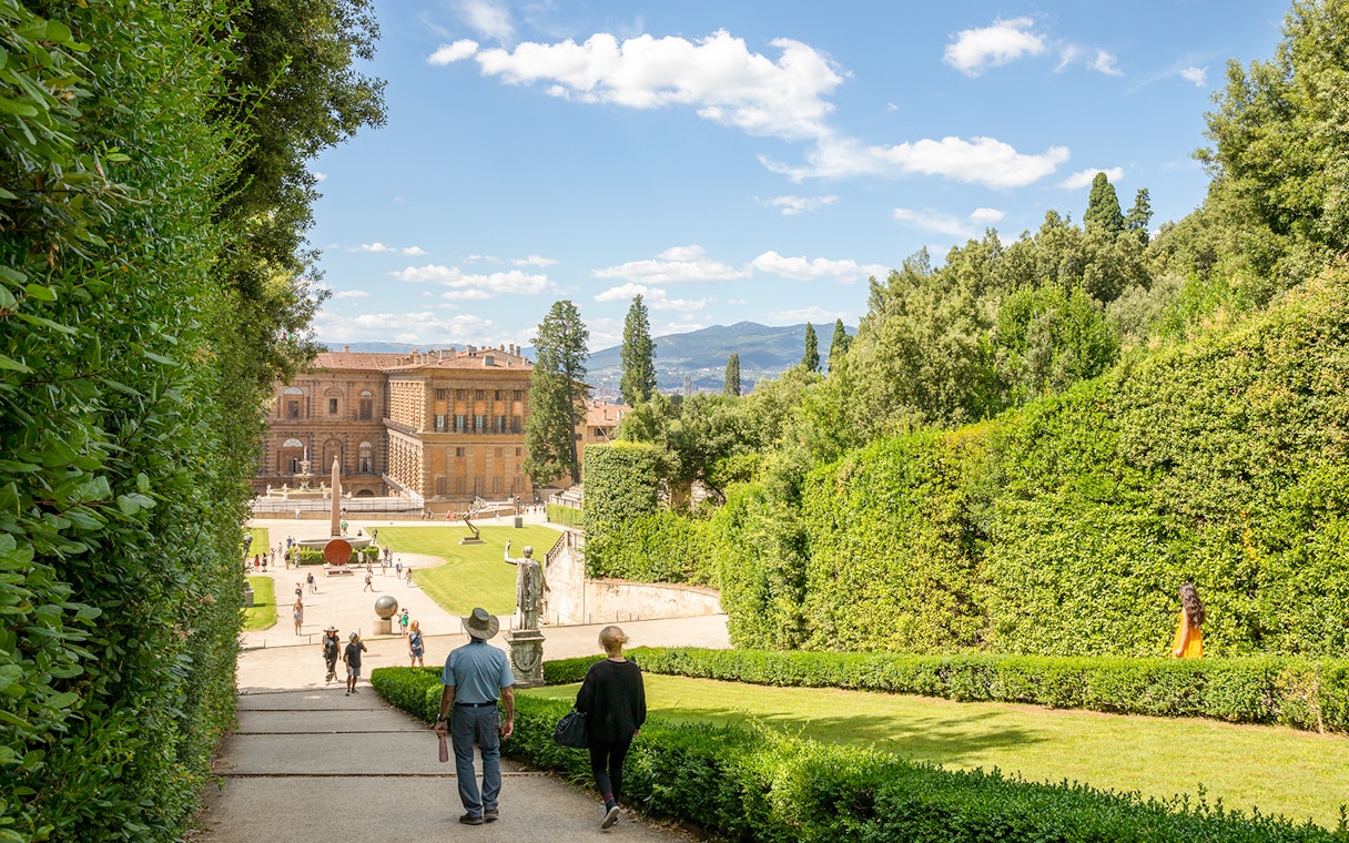 Visitors walking towards Pitti Palace through Boboli Garden in Florence, Italy.