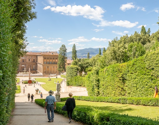 Visitors walking towards Pitti Palace through Boboli Garden in Florence, Italy.