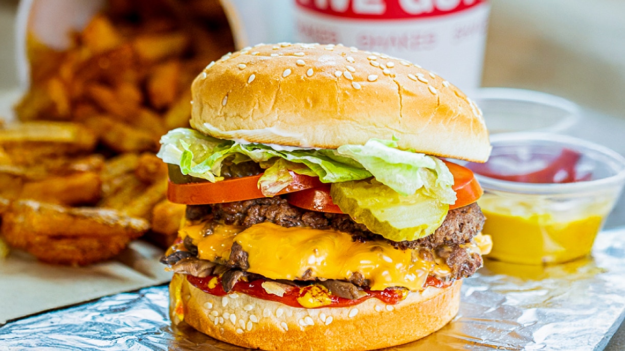 Person ziplining over Dubai Marina with skyscrapers in view, part of Xline Dubai Marina Zipline plus burger tour.