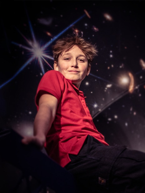 Child enjoying The TUBE experience in Copenhagen with a cosmic backdrop.