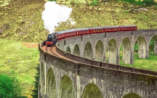 Jacobite Steam Train crossing Glenfinnan Viaduct in Scotland.