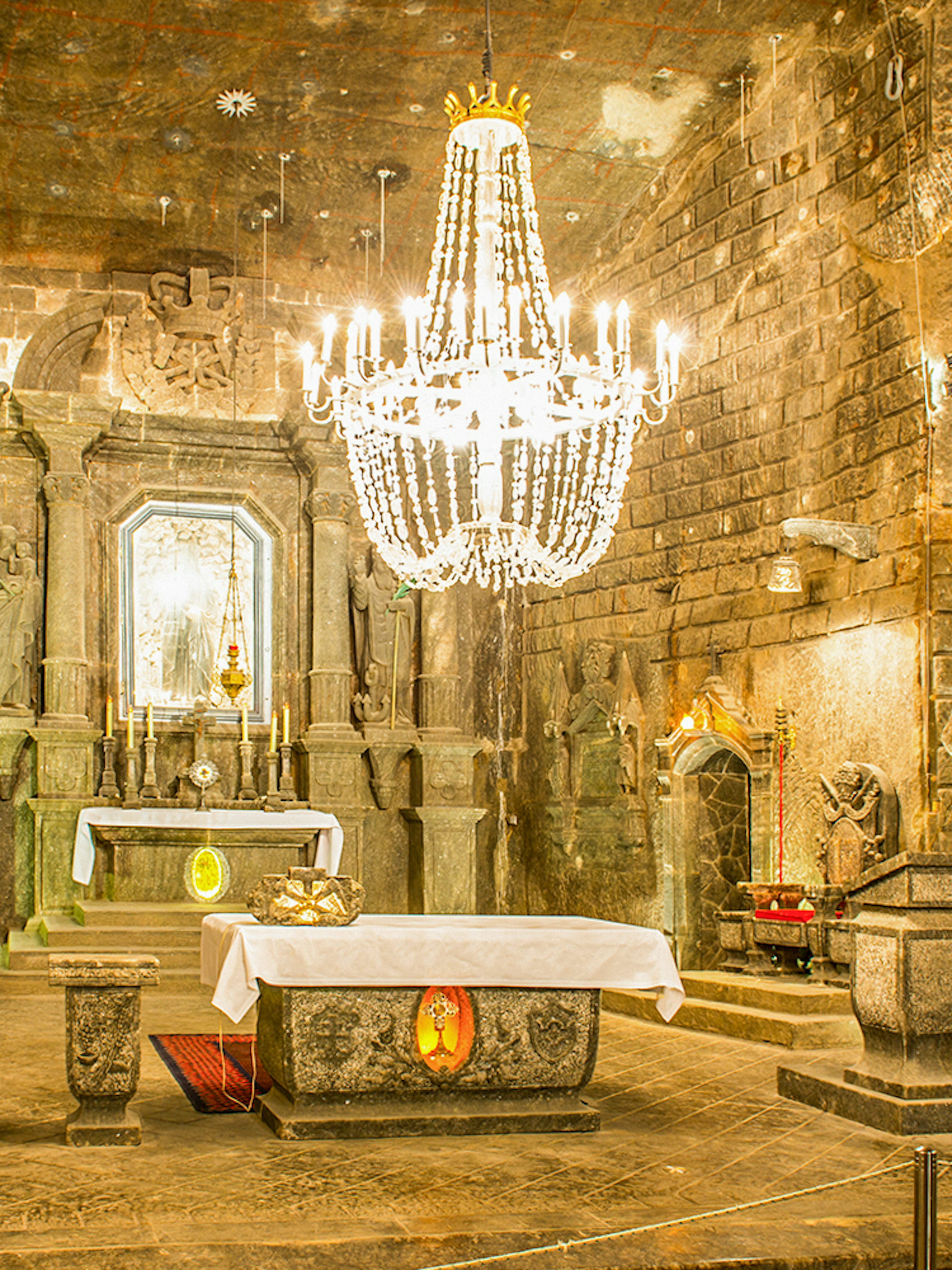 Chapel of Saint Kinga in Wieliczka salt mine with altar and chandelier.