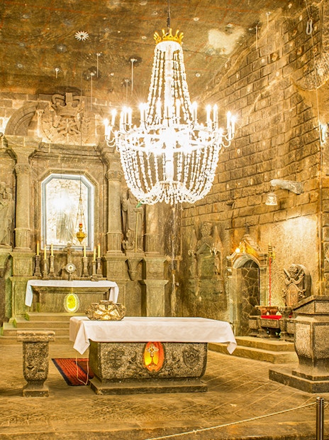 Chapel of Saint Kinga in Wieliczka salt mine with altar and chandelier.