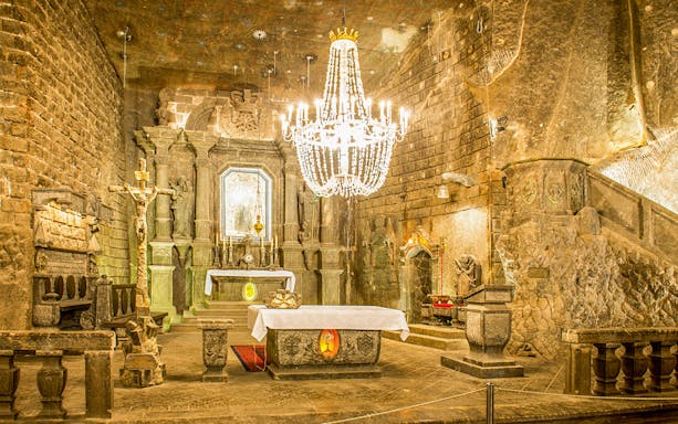 Chapel of Saint Kinga in Wieliczka salt mine with altar and chandelier.