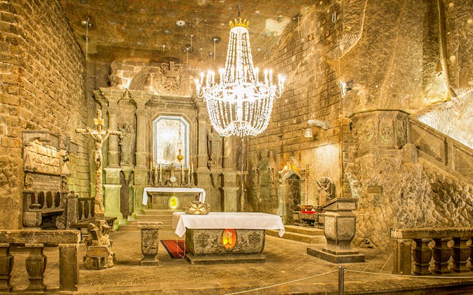 Chapel of Saint Kinga in Wieliczka salt mine with altar and chandelier.