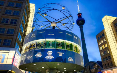 World clock and TV tower illuminated during Berlin Lights Festival.