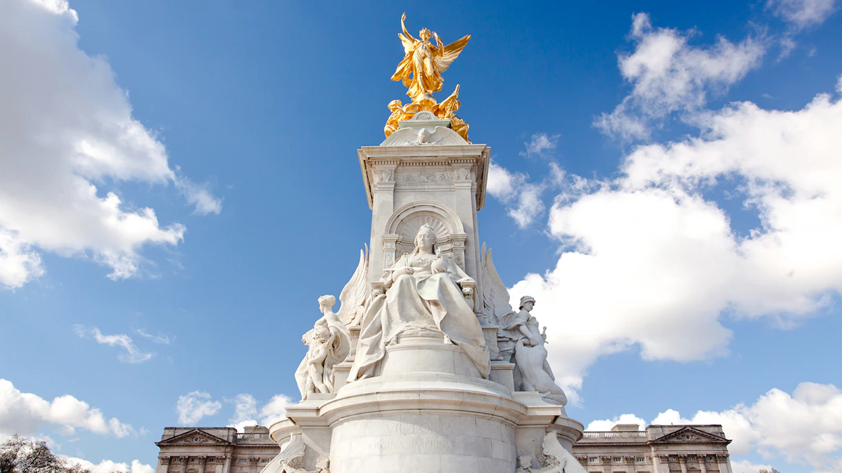 Buckingham Palace Memorial with Queen Victoria statue under a blue sky.