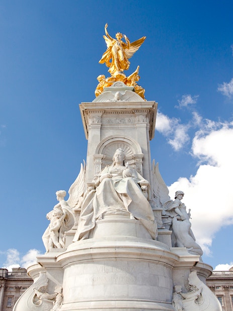 Buckingham Palace Memorial with Queen Victoria statue under a blue sky.