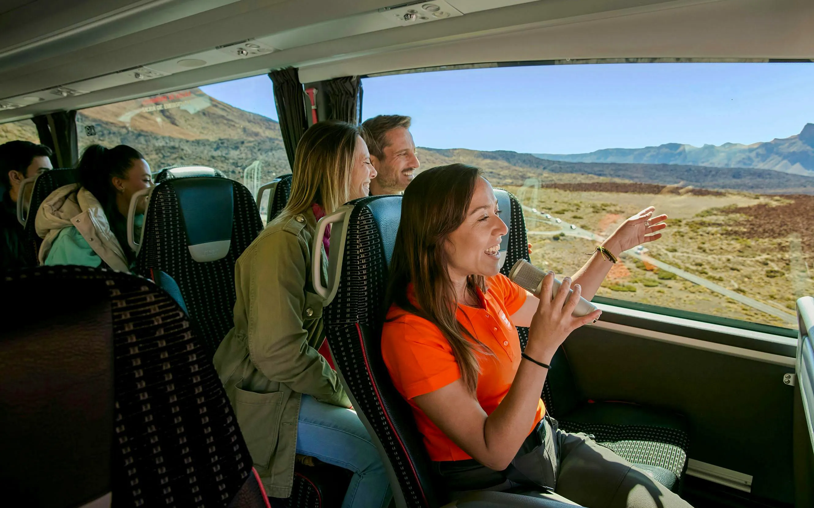 Tour guide speaking to guests on a bus during Mount Teide tour in Tenerife.