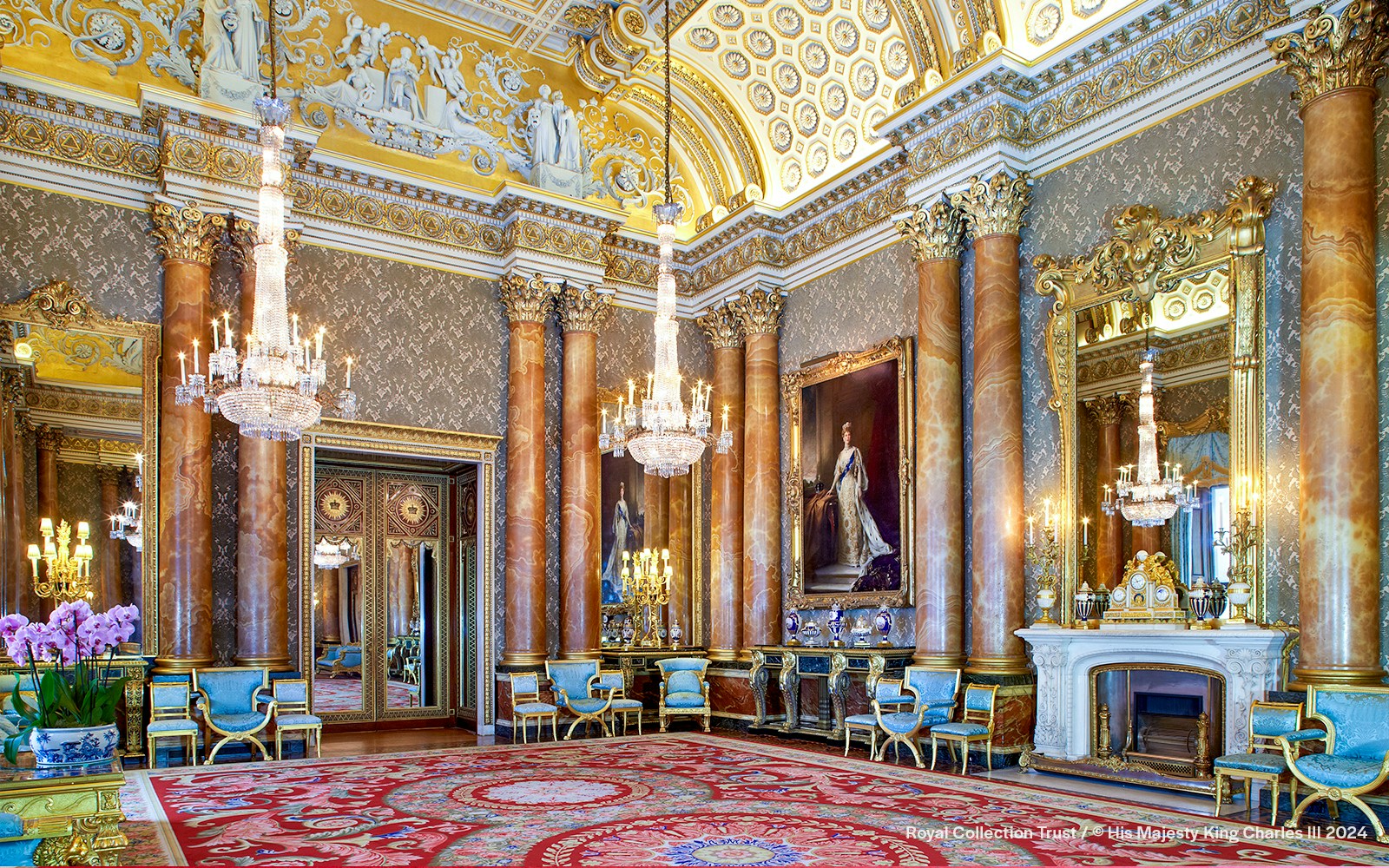 Blue Drawing Room at Buckingham Palace with chandeliers, ornate columns, and regal portraits.