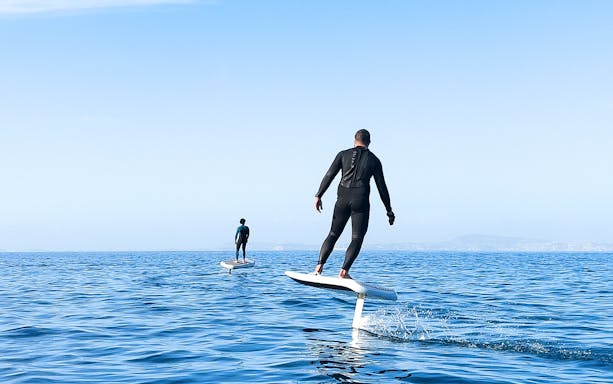 Two people e-foiling on the sea near Capri, Italy.