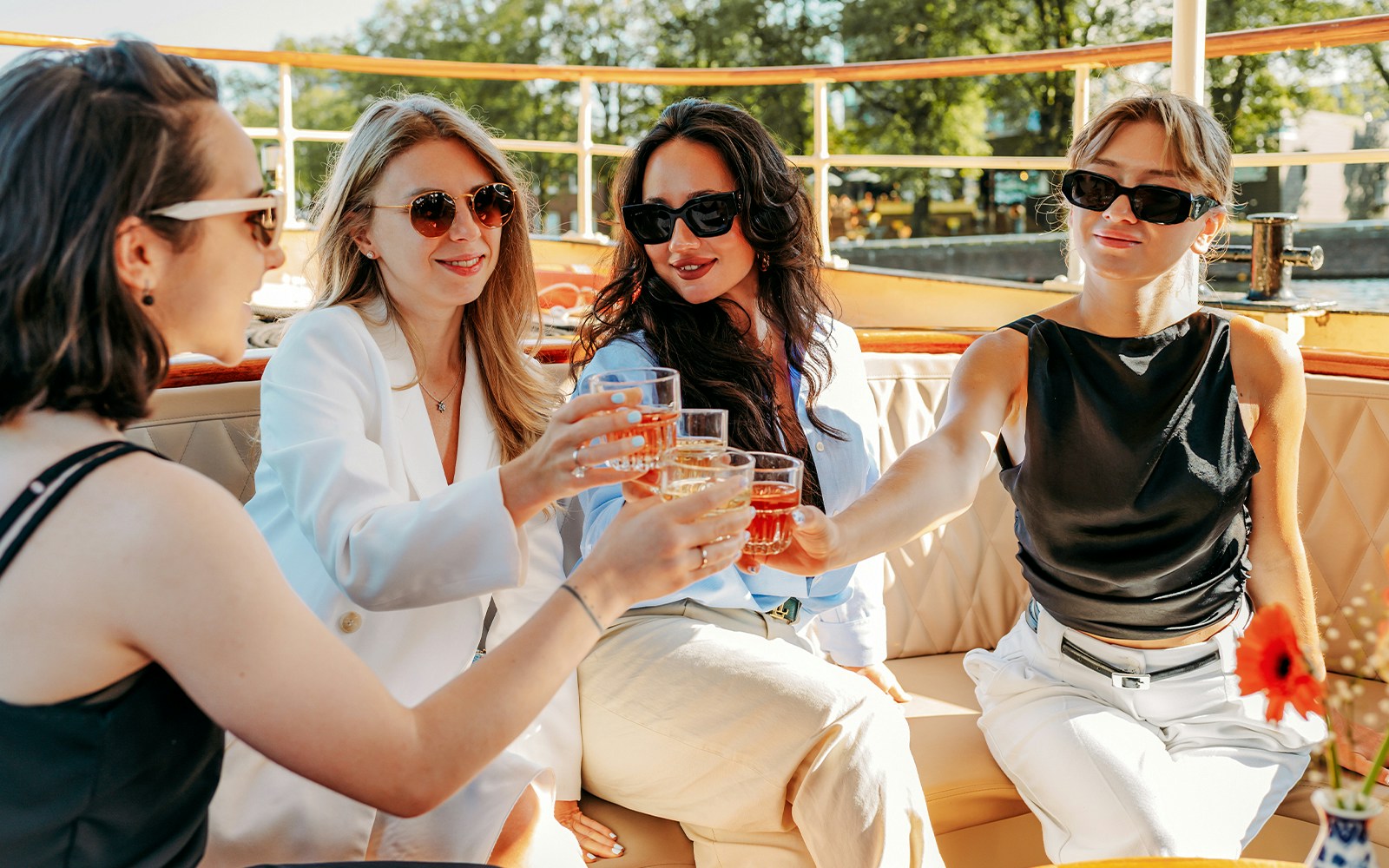 Guests enjoying wine and cheese on a luxury canal cruise in Amsterdam.