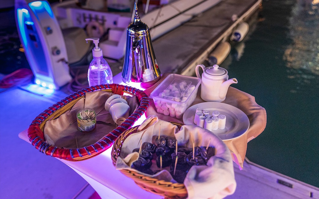 Refreshments and dates on a table during a Dhow Dinner Cruise in Dubai Creek.