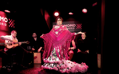 Flamenco dancer performing at Cardamomo in Madrid with musicians playing guitar.