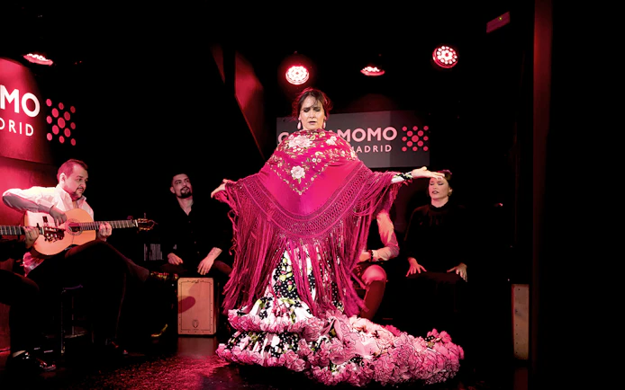 Flamenco dancer performing at Cardamomo in Madrid with musicians playing guitar.