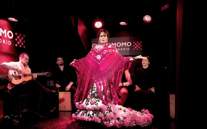 Flamenco dancer performing at Cardamomo in Madrid with musicians playing guitar.