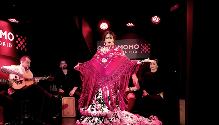 Flamenco dancer performing at Cardamomo in Madrid with musicians playing guitar.