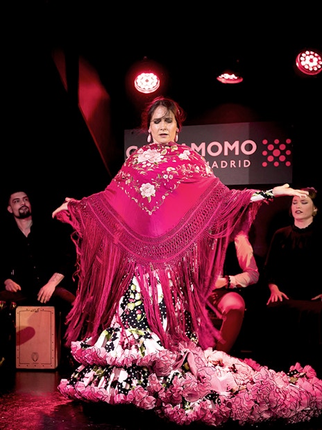 Flamenco dancer performing at Cardamomo in Madrid with musicians playing guitar.