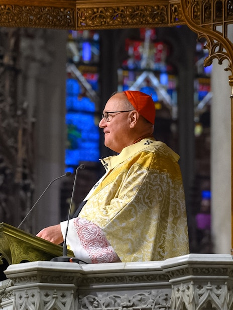 Clergy member speaking at St. Patrick's Cathedral event, New York City.