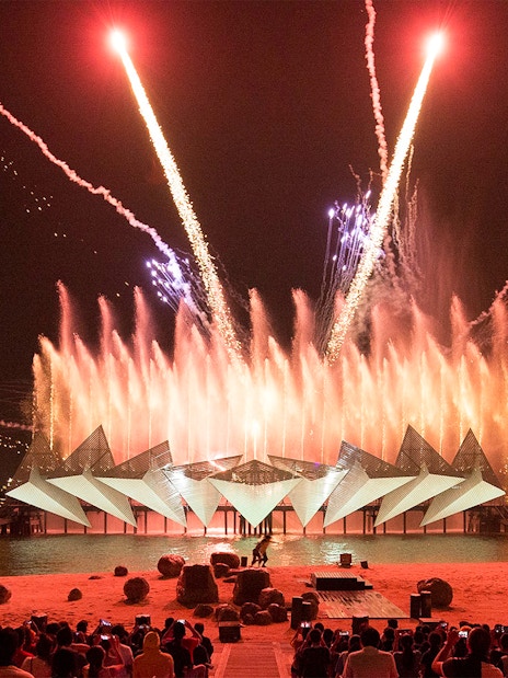 Tourists watching the Wings of Time light and sound show at Sentosa Island, Singapore.