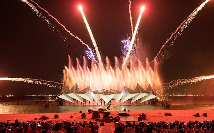 Tourists watching the Wings of Time light and sound show at Sentosa Island, Singapore.