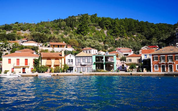 Colorful waterfront buildings in Vathi town, Ithaca, viewed from a cruise in Kefalonia, Greece.