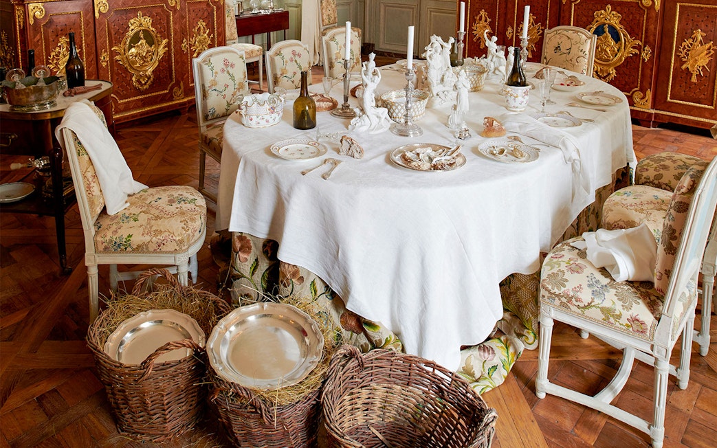 Elegant dining room setup at Hôtel de la Marine with ornate tableware and chairs.