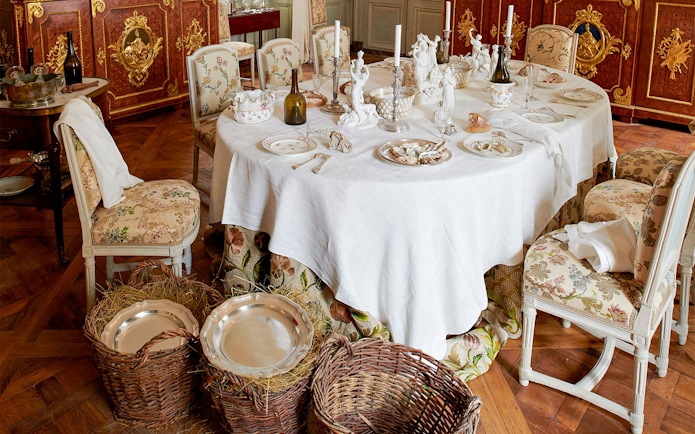 Elegant dining room setup at Hôtel de la Marine with ornate tableware and chairs.