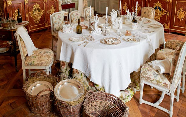 Elegant dining room setup at Hôtel de la Marine with ornate tableware and chairs.