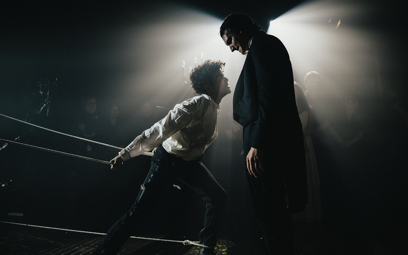 Masquerade Broadway stage performance with two actors in dramatic spotlight.
