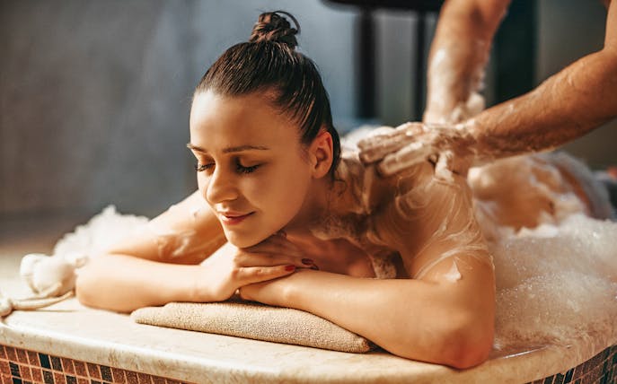 Person enjoying a foam massage at a historical hammam in Istanbul, Turkey.