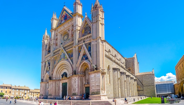 Cathedral of Orvieto facade with intricate carvings and colorful mosaics, Italy.