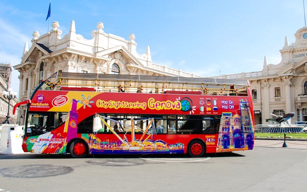 City Sightseeing Genova bus in front of historic building in Italy.