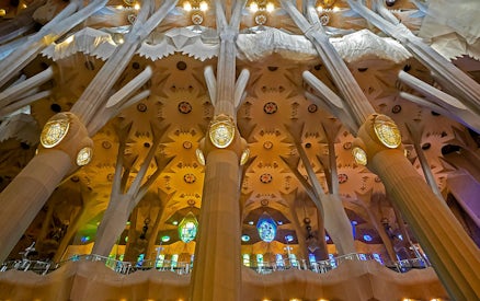 Sagrada Familia interior with ornate columns and colorful stained glass windows.