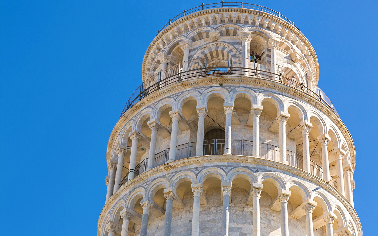 Leaning Tower of Pisa close-up with blue sky background.