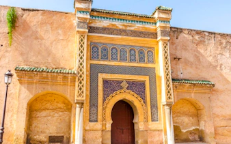 Historic gate with intricate tilework in Meknes, Morocco.