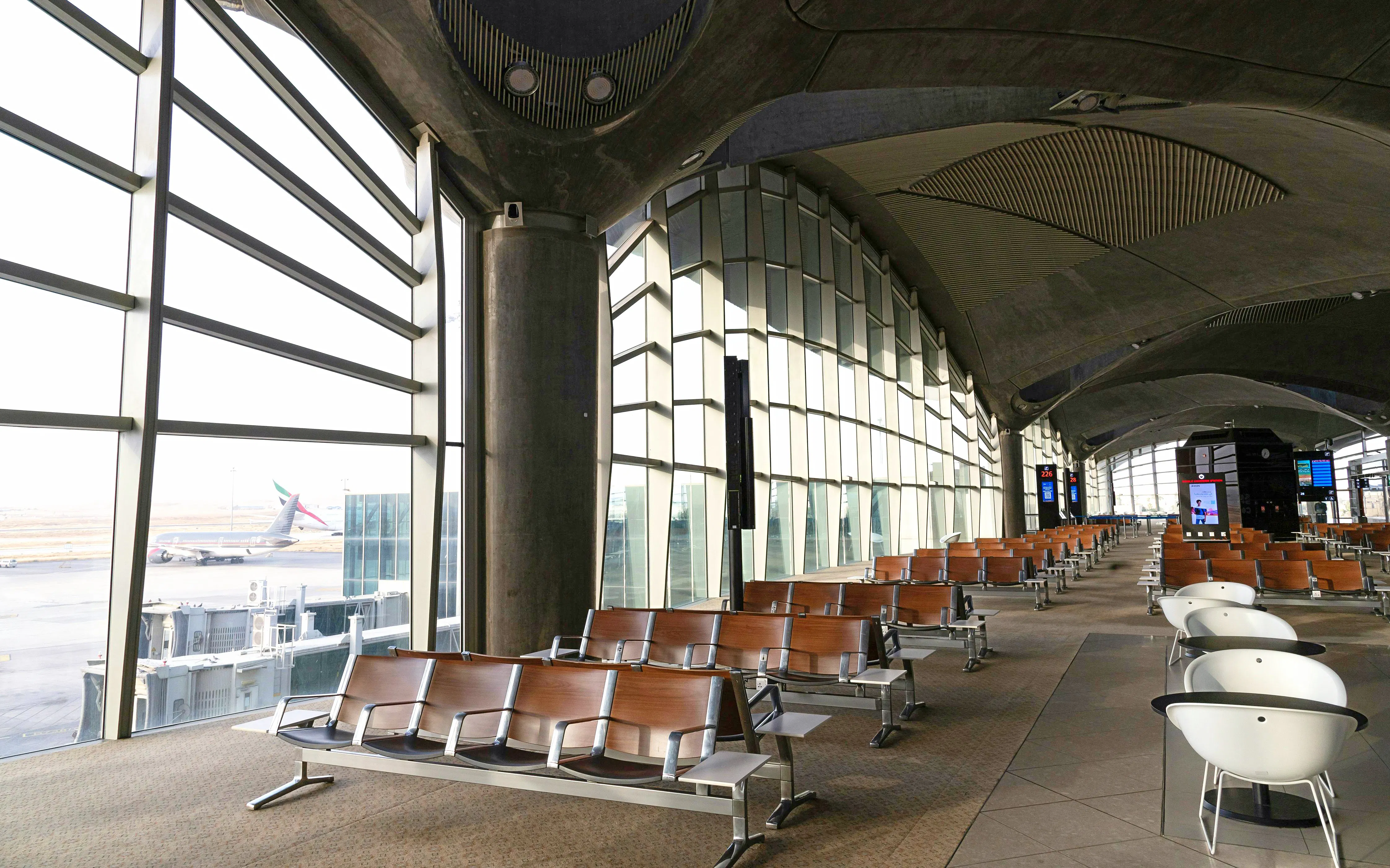 Modern waiting area inside Queen Alia International Airport, Amman, with large windows and seating.