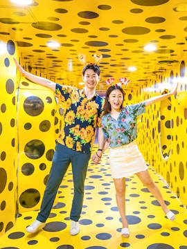 Couple enjoying a polka dot art installation in Busan during a day tour.