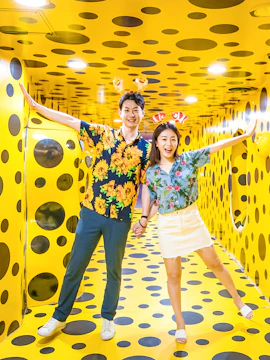 Couple enjoying a polka dot art installation in Busan during a day tour.