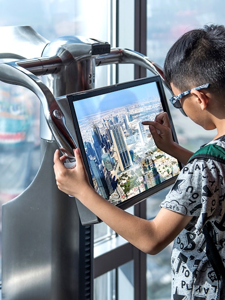 Visitor using interactive screen at Burj Khalifa observation deck, Dubai.