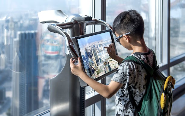 Visitor using interactive screen at Burj Khalifa observation deck, Dubai.