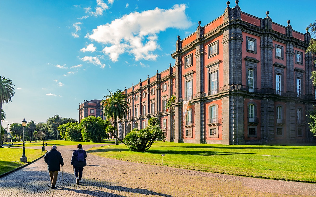 Capodimonte Museum exterior with visitors walking on a sunny day in Naples, Italy.