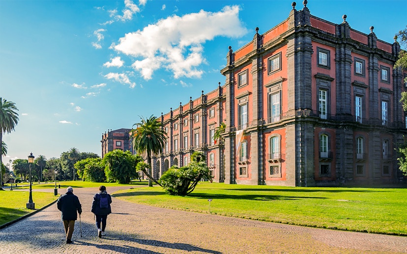 Capodimonte Museum exterior with visitors walking on a sunny day in Naples, Italy.