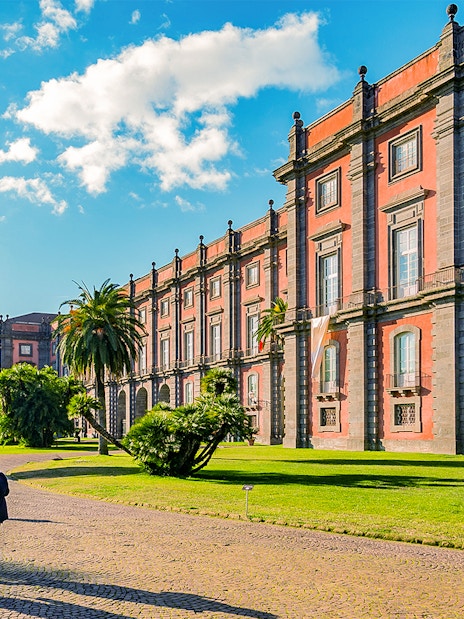Capodimonte Museum exterior with visitors walking on a sunny day in Naples, Italy.