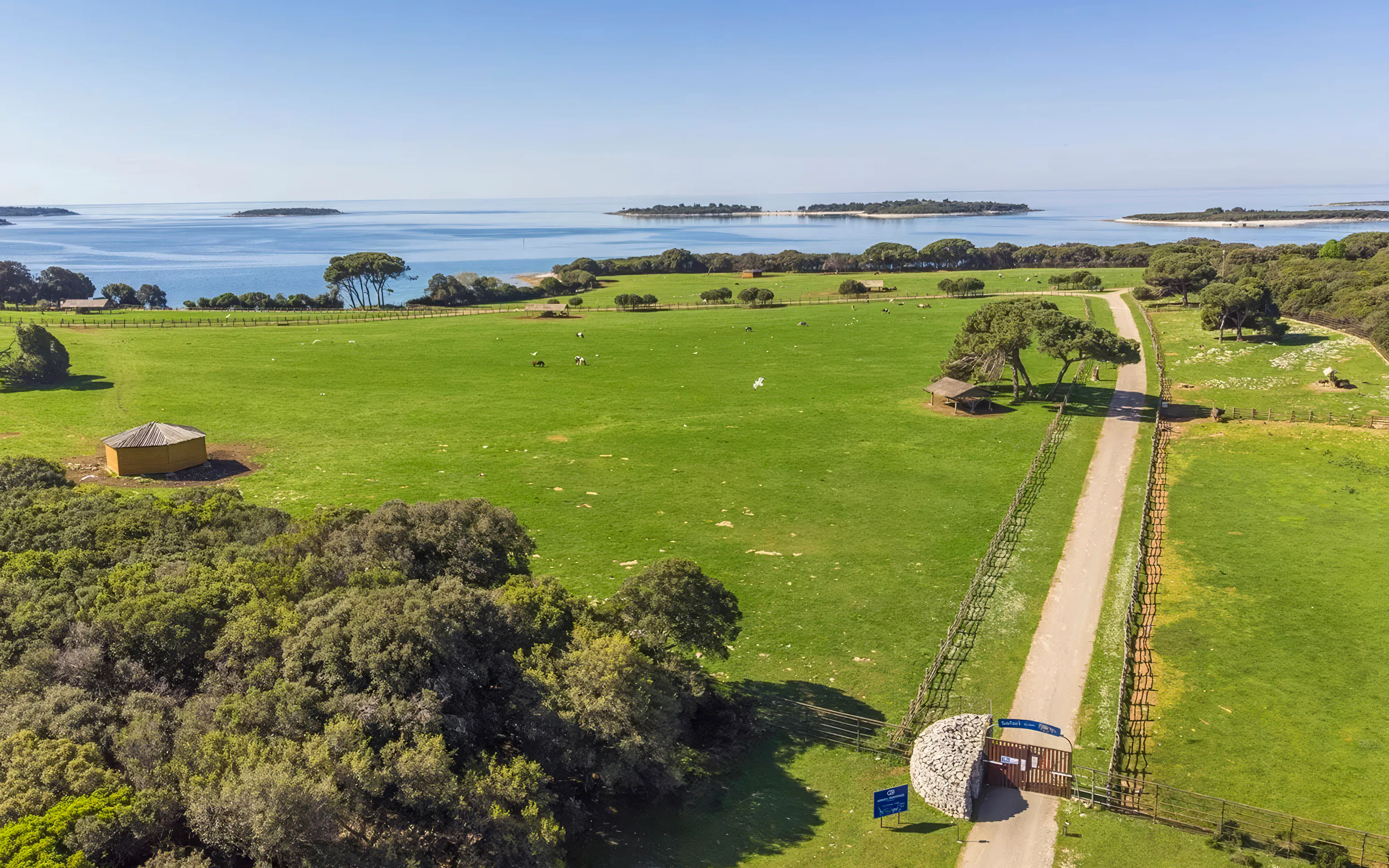 Aerial view of Brijuni National Park's green fields and coastline from Fažana tour.