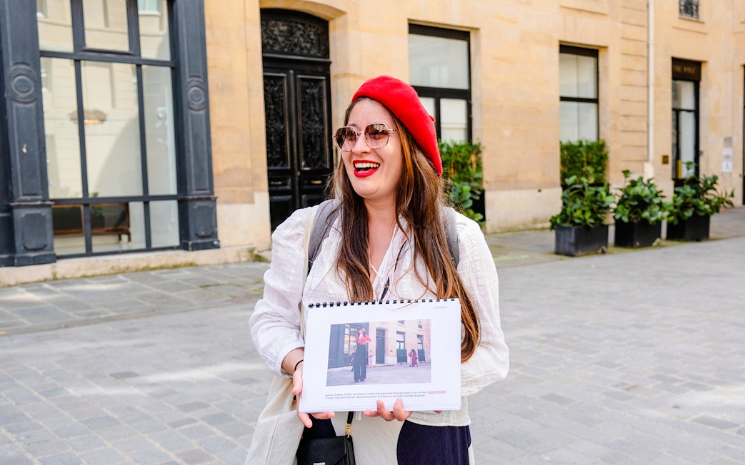 Guide holding photos during Emily in Paris Locations Walking Tour in Paris.