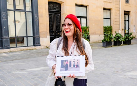 Guide holding photos during Emily in Paris Locations Walking Tour in Paris.