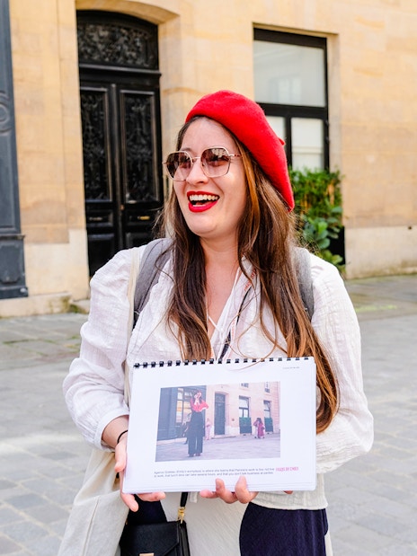 Guide holding photos during Emily in Paris Locations Walking Tour in Paris.