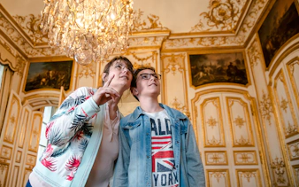 Visitors admiring ornate interior of Chateau of Chantilly.
