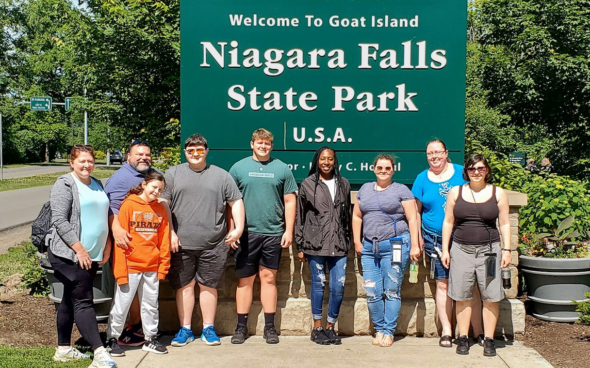 Group at Niagara Falls State Park entrance, New York, near Maid of the Mist and Cave of the Winds tours.